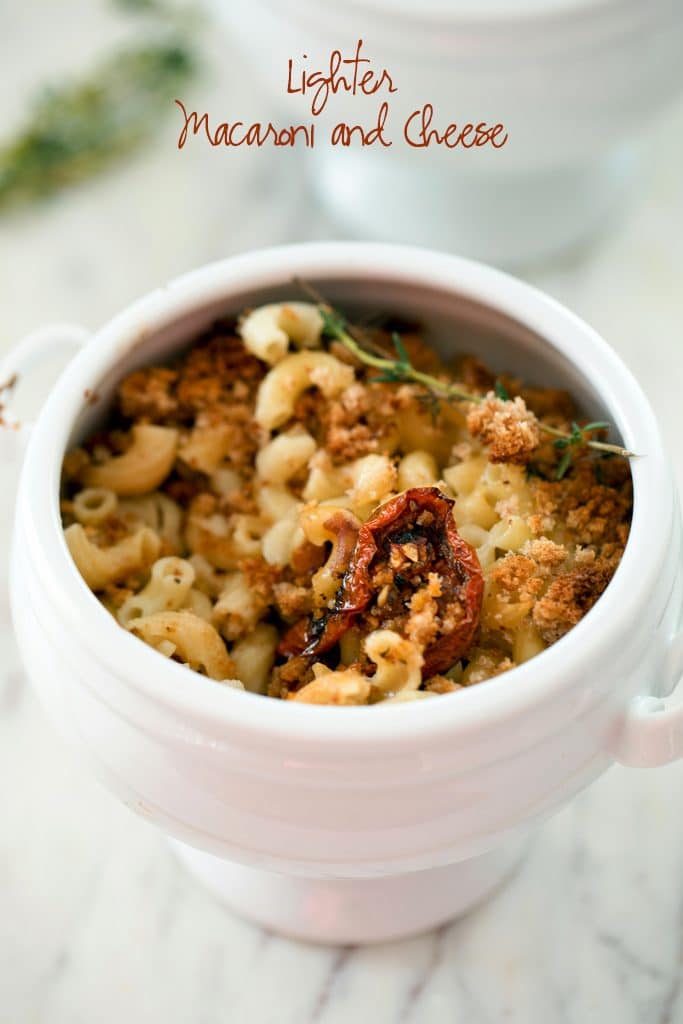 Overhead view of a white ramekin of lighter mac and cheese with roasted tomatoes and thyme with recipe title at top