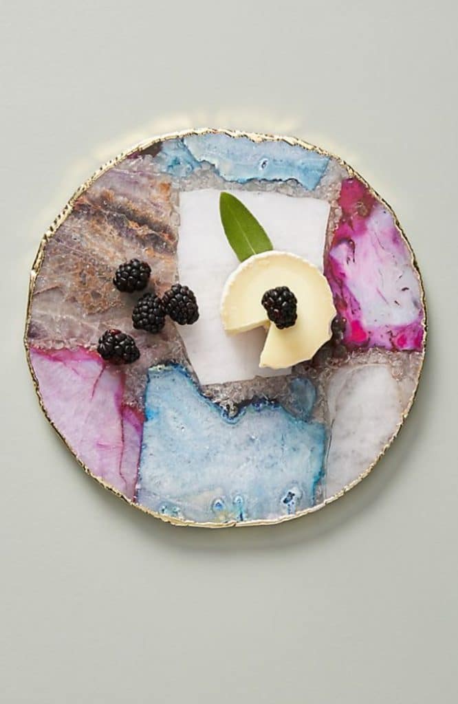 Overhead view of pretty colored agate cheese plate with cheese and berries on it