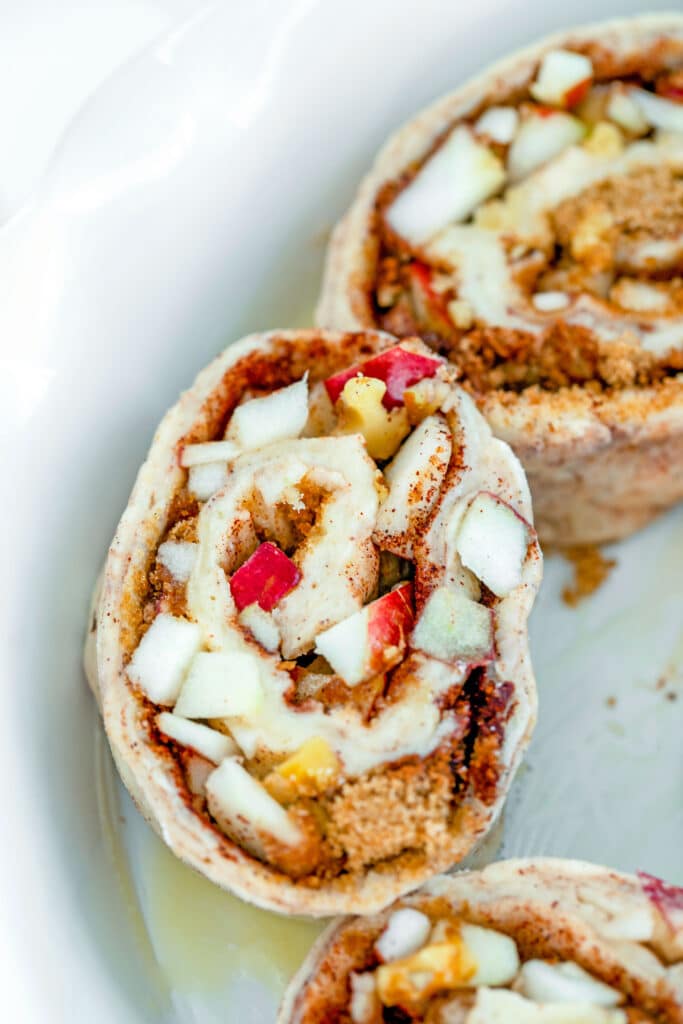Overhead view of a sliced apple walnut cinnamon roll in a pie dish
