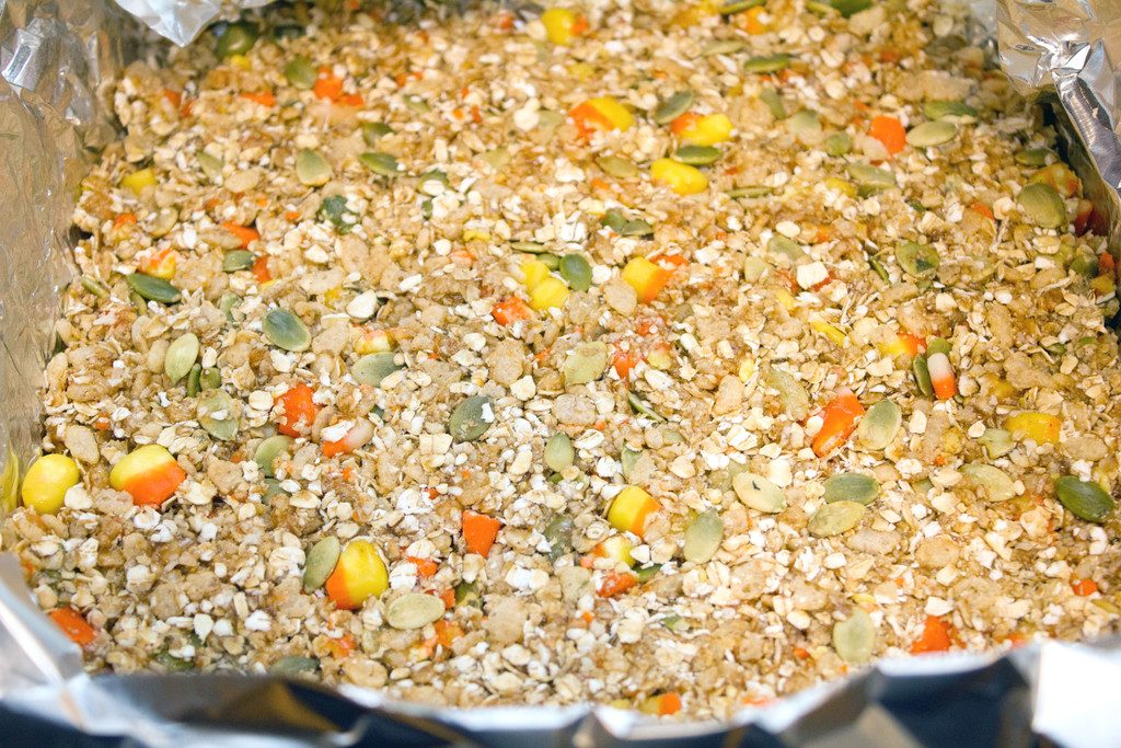 Candy corn granola bar mixture poured into pan and cooling