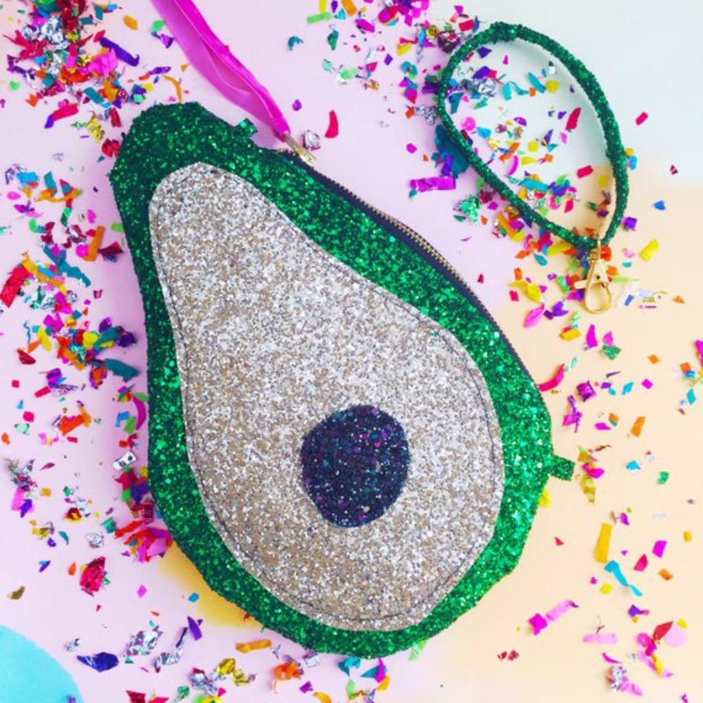 Overhead view of sparkly avocado clutch purse surrounded by confetti