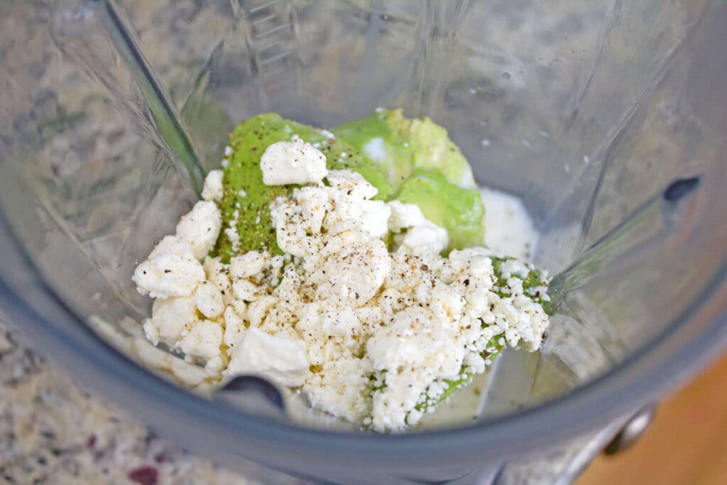 overhead view of avocado, feta, lime juice, milk, and pepper in blender