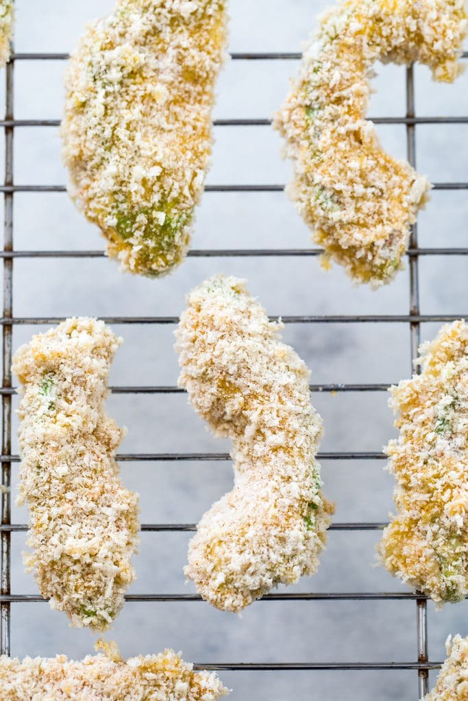 A metal baking rack topped with panko-coated avocado slices