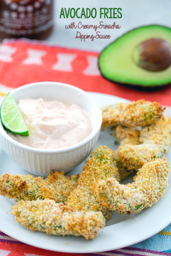 Overhead shot of panko-coated avocado fries with a bowl of sriracha dipping sauce with a lime in it and half an avocado in the background with "Avocado Fries with Creamy Sriracha Dipping Sauce" text at the top