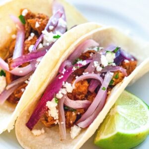 BBQ Chicken Tacos -- Looking to switch up your regular taco night? These easy-to-make BBQ Chicken Tacos are made with a homemade BBQ sauce, sautéed onions, and queso fresco cheese | wearenotmartha.com