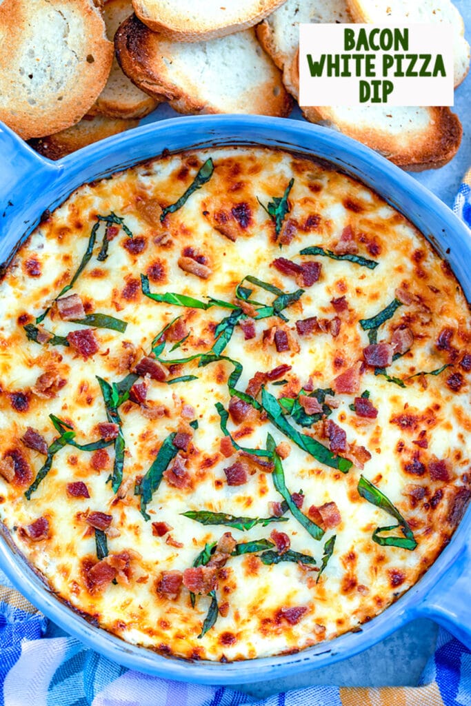 Bird's eye view of bacon white pizza dish topped with basil in a blue pie dish surrounded by crostini with recipe title at top of image