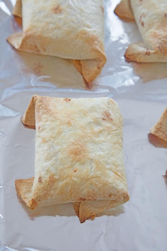 Chimichangas baked and golden on baking sheet