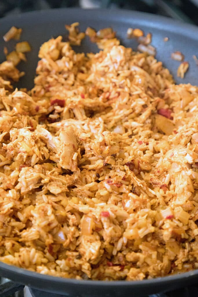 Rice added to onion, chipotle, chicken mixture in skillet