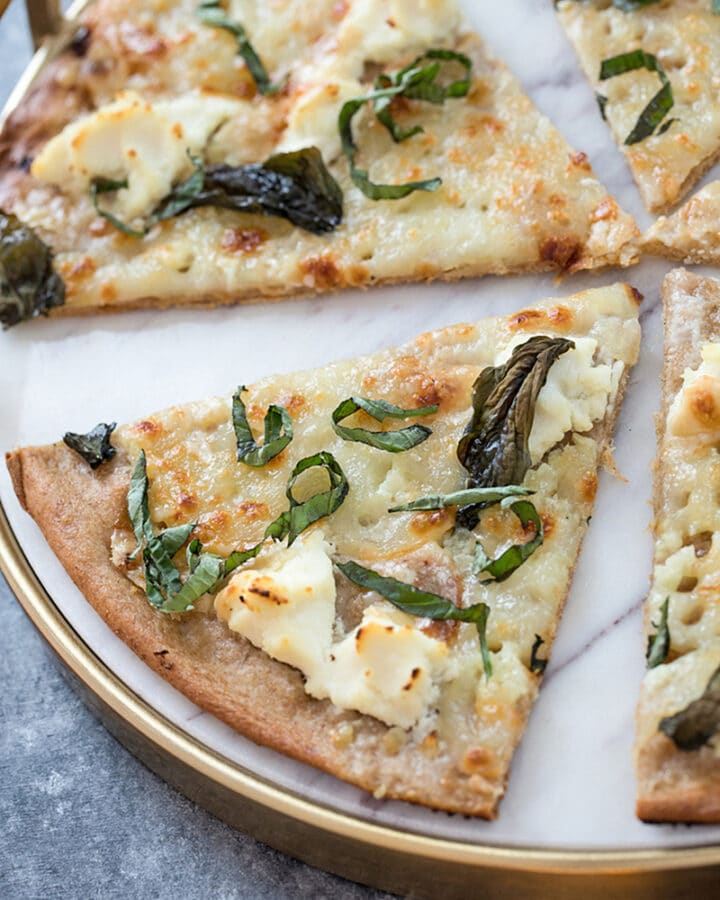 Basil and Garlic White Pizza -- Traditional pizza is always delicious, but there's something about a cheese-filled white pizza that really hits the spot. Add on a slathering of garlic oil and plenty of basil and you'll be in pizza heaven | wearenotmartha.com #pizza #whitepizza #wholewheatdough