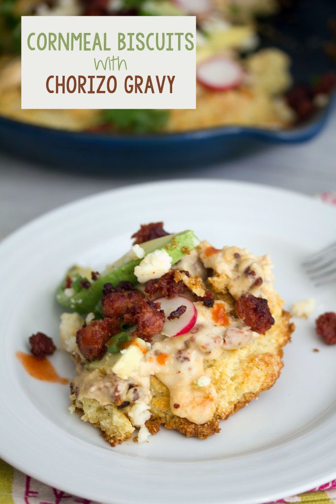 Close-up view of a cornmeal biscuit with chorizo gravy topped with radishes, cheese, and avocado with recipe title at top of image