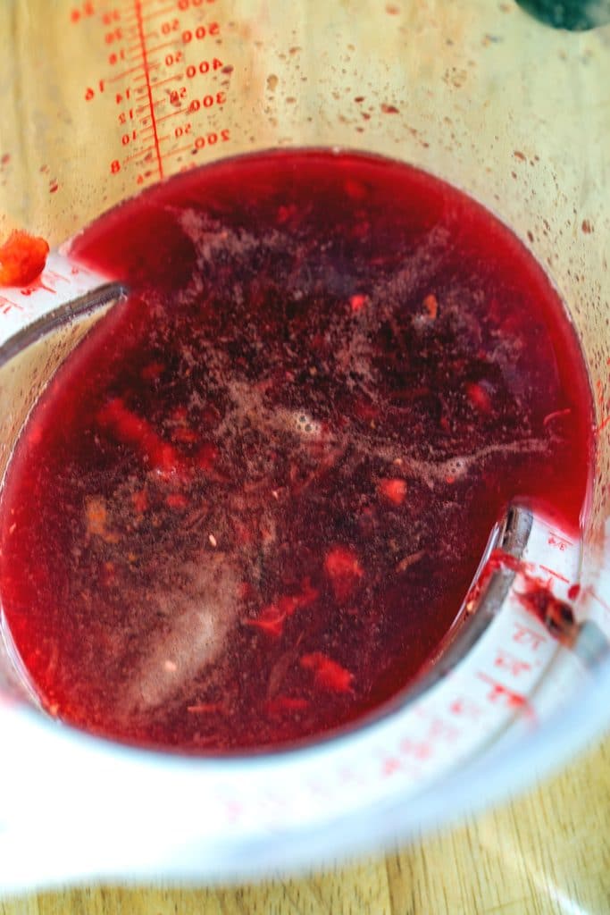 Freshly squeezed blood orange juice in a measuring cup