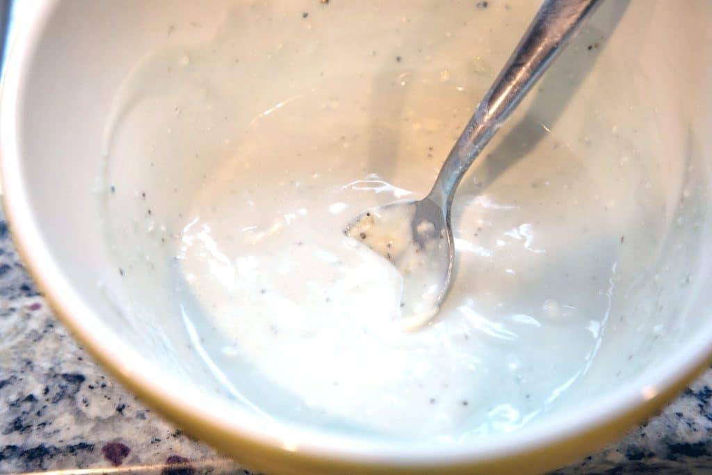 Overhead view of homemade blue cheese dressing in a bowl with a spoon