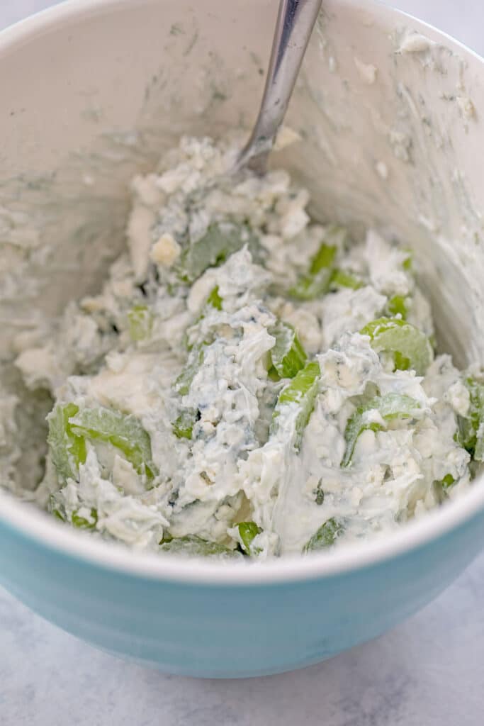 Blue cheese spread with celery in bowl.