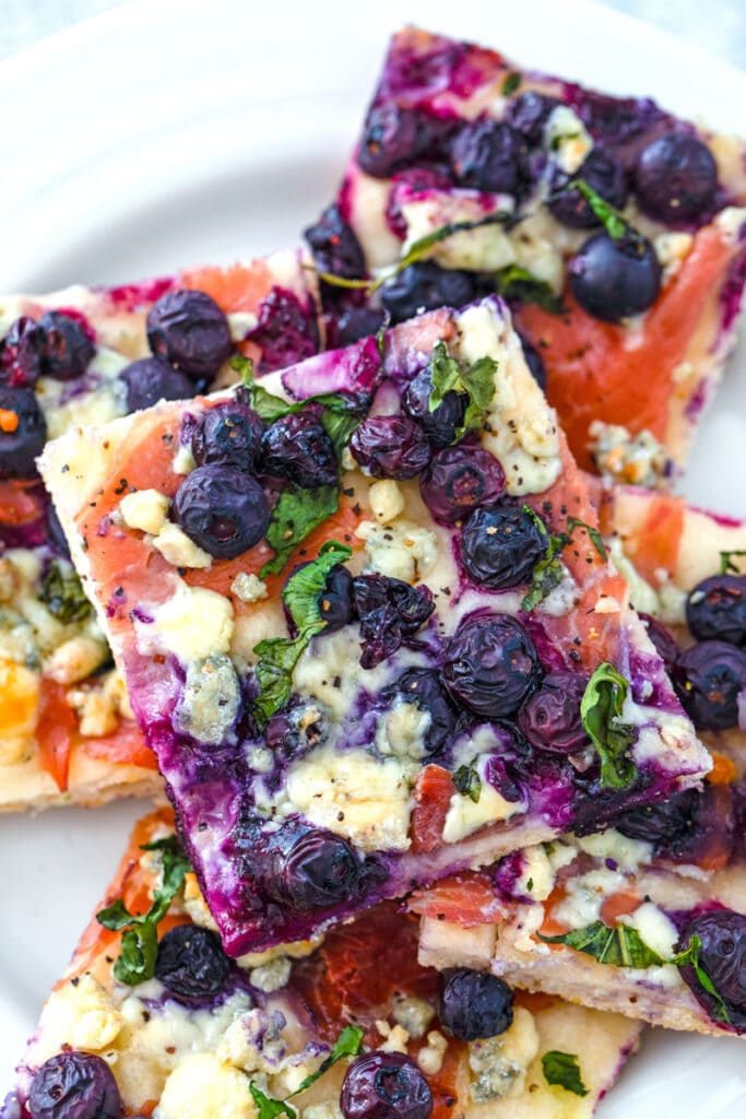Square slices of blueberry blue cheese pizza on a plate