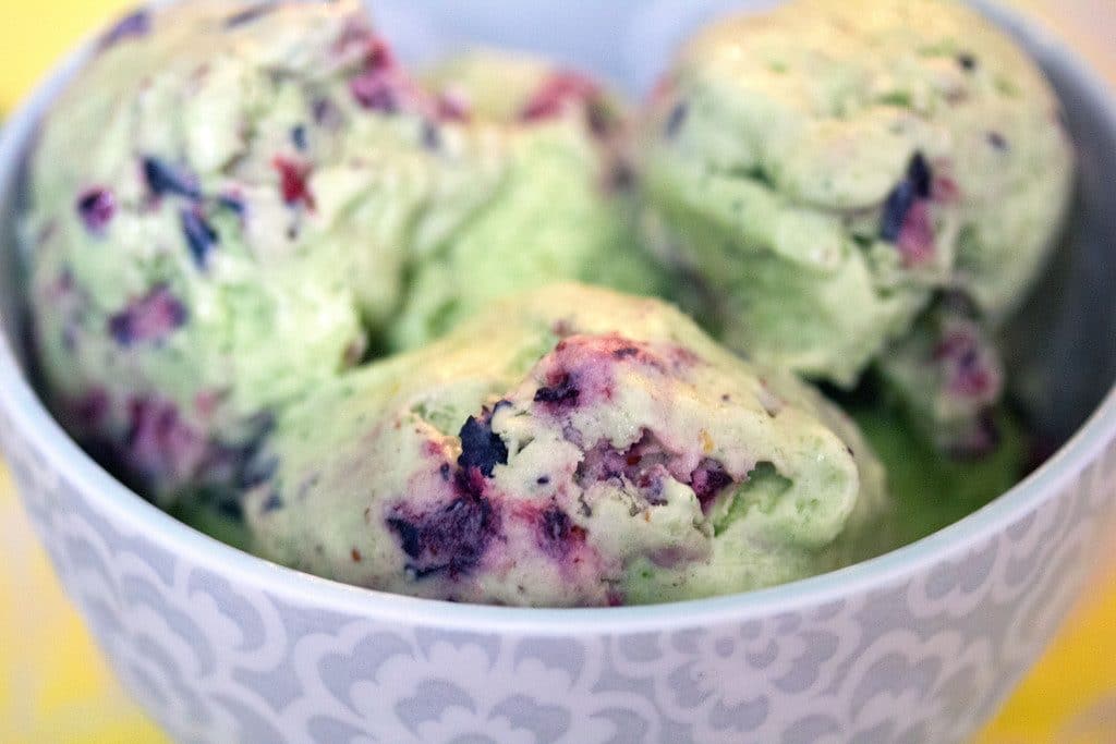 Landscape head-on close-up view of blueberry kale ice cream in a grey bowl