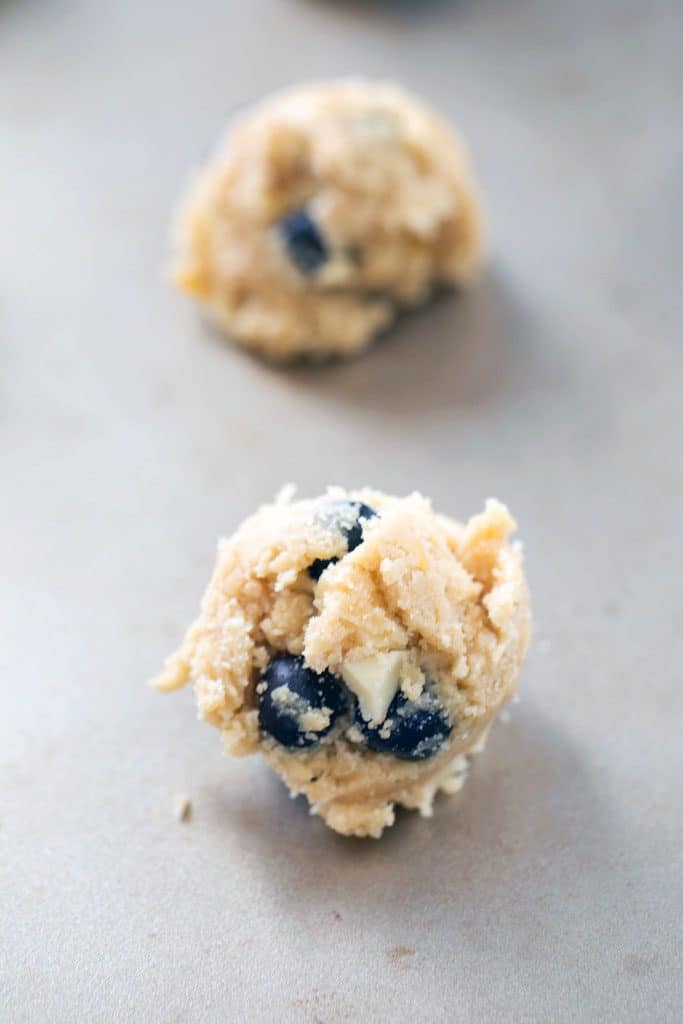 Blueberry, lemon, white chocolate chunk cookie batter scoops on baking sheet