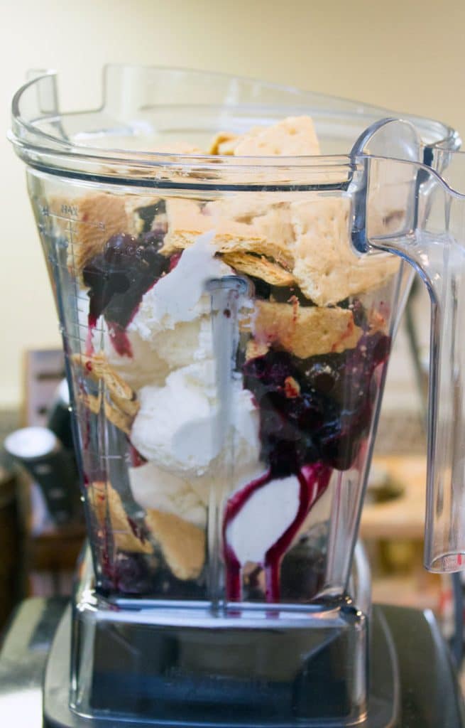 Vanilla ice cream, blueberry puree syrup, and graham crackers in Vitamix blender ready to be turned into a blueberry pie milkshake