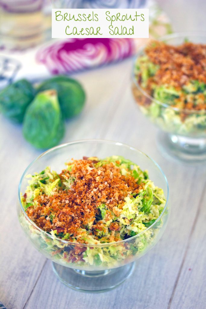 Head-on closeup view of bowl of brussels sprouts bacon caesar salad topped with panko with second bowl of salad, brussels sprouts, and recipe title at top