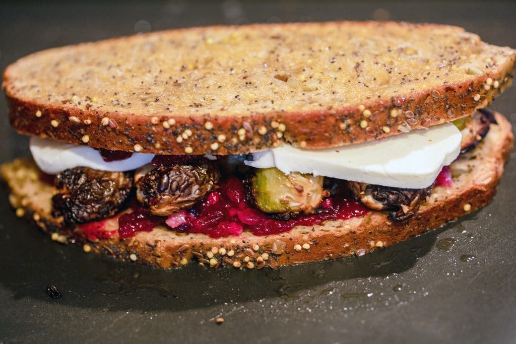 Brussels sprouts and cranberry relish grilled cheese cooking on a griddle