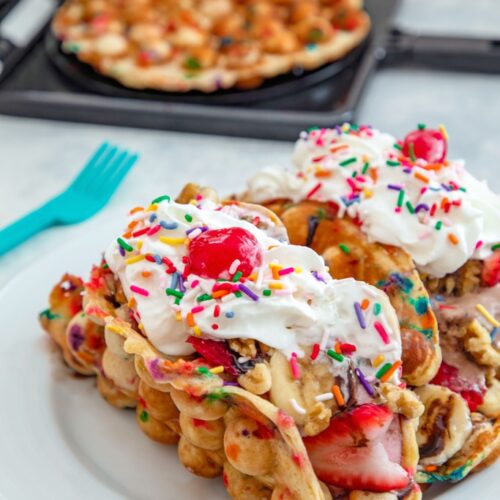 Bubble Waffle Banana Split Tacos -- These super fun Bubble Waffle Banana Split Tacos are perfect for brunch or dessert. The banana funfetti bubble waffles are formed into “taco” shells and filled with ice cream, bananas, strawberries, chocolate sauce, walnuts, whipped cream, and sprinkles! | wearenotmartha.com