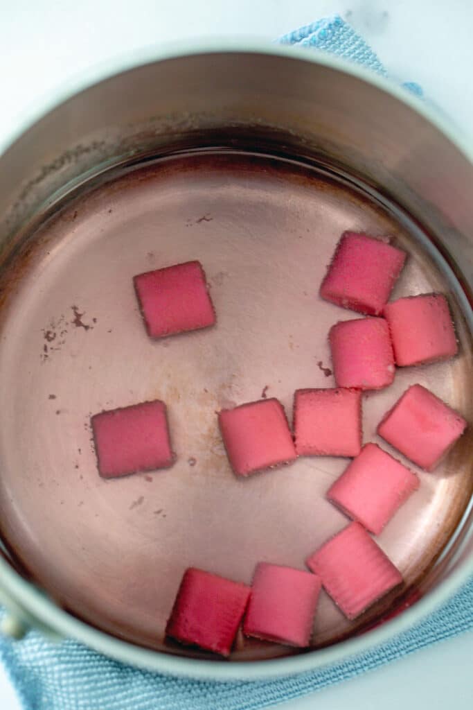 Overhead view of saucepan with pieces of bubblegum in sugar water.