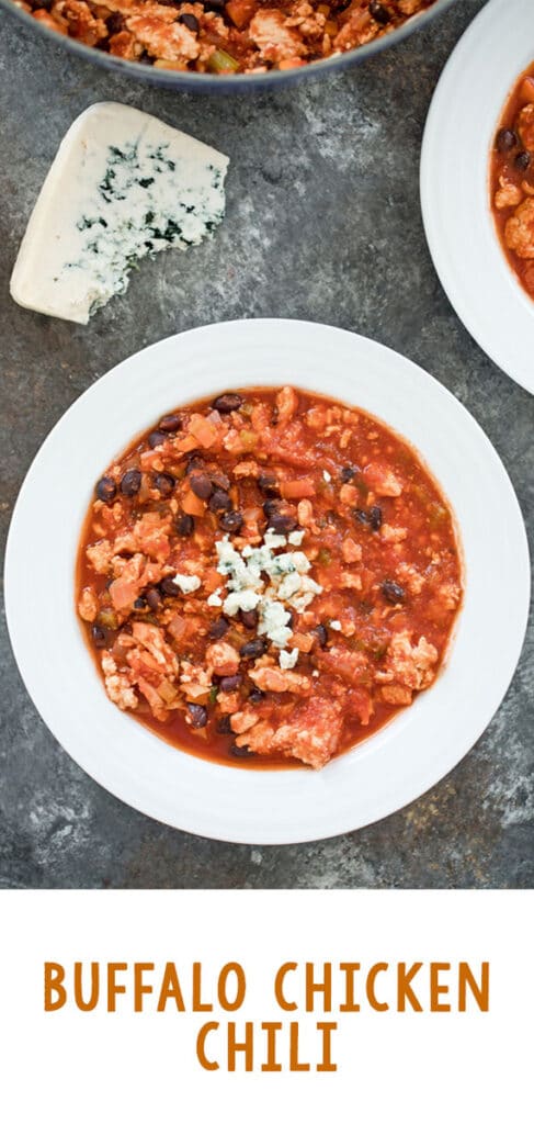 Long Pinterest image with overhead view of bowl of buffalo chicken chili with wedge of blue cheese with recipe title at bottom
