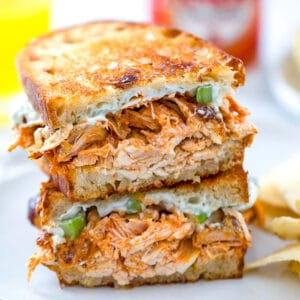 Close-up view of a buffalo chicken grilled cheese sandwich with blue cheese spread and celery.