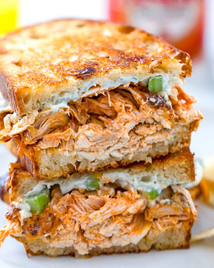 Close-up view of a buffalo chicken grilled cheese sandwich with blue cheese spread and celery.