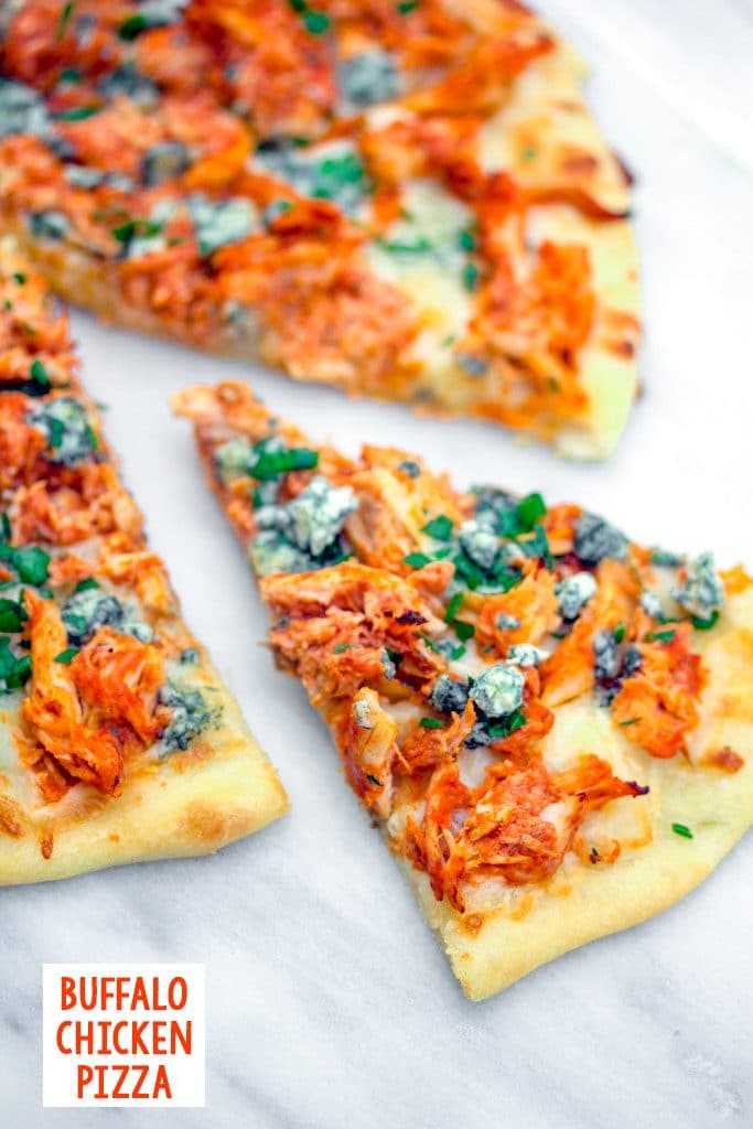 Overhead view of a slice of buffalo chicken pizza pulled out from the rest of the pizza on a marble surface with recipe title at bottom of photo