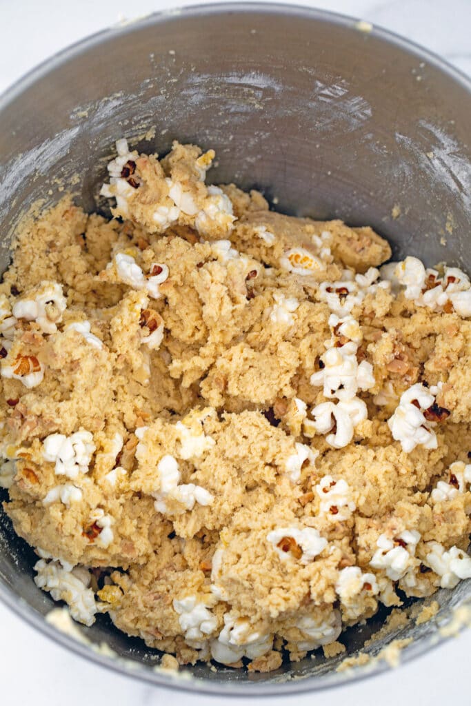 Buttered popcorn cookie dough with toffee pieces in mixing bowl