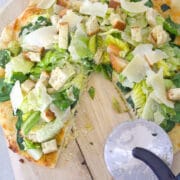 Caesar Salad Pizza -- This Caesar Salad Pizza combines pizza and salad with a thin crust parmesan dough, lots of cheese, spinach and romaine, and a creamy dressing | wearenotmartha.com
