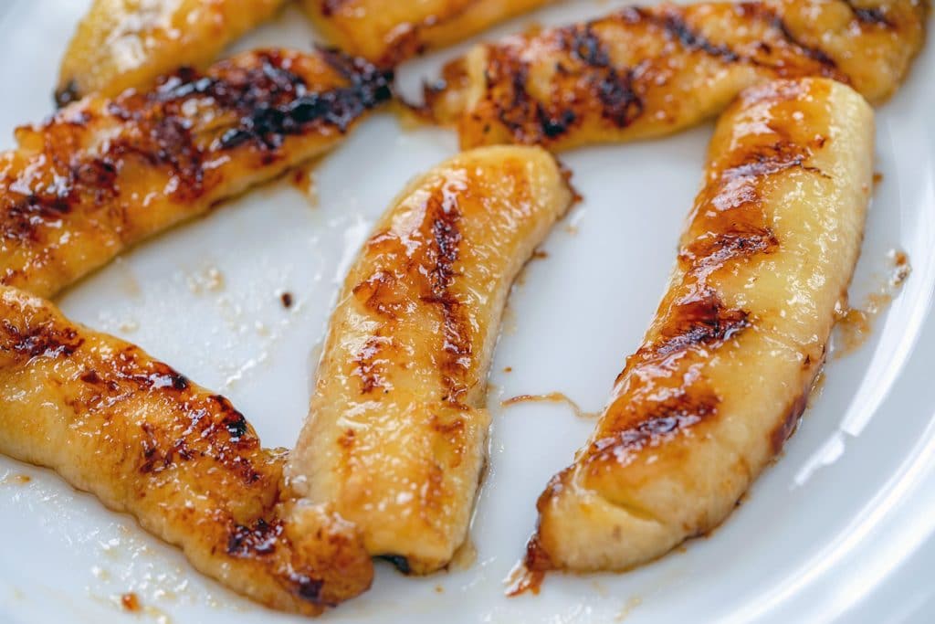 Overhead view of caramelized bananas on white plate