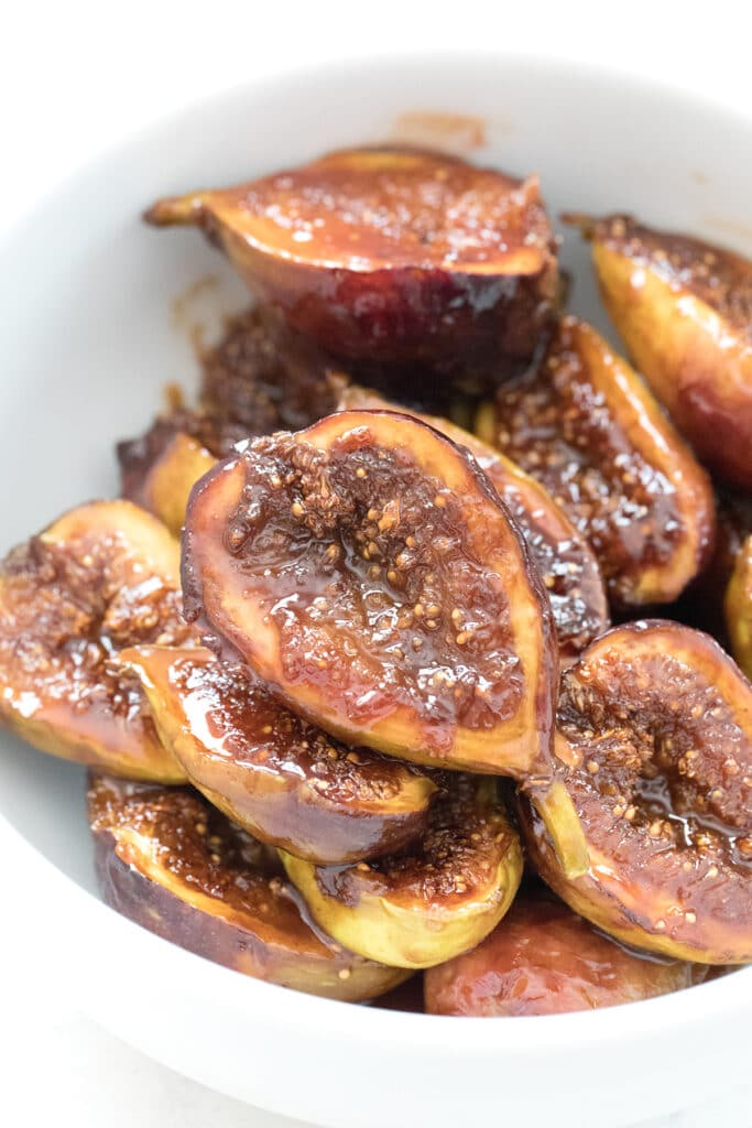 Overhead close-up view of caramelized figs in a white bowl