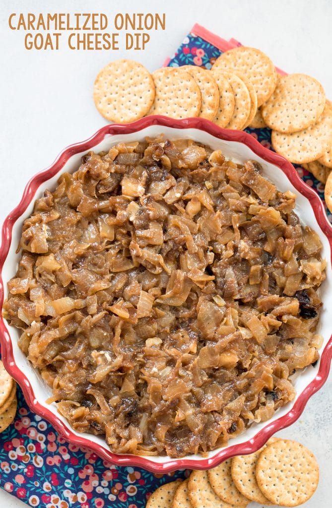 Overhead view of caramelized onion goat cheese dip in a pie plate, surrounded by crackers with recipe name at top