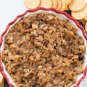 Overhead view of caramelized onion goat cheese dip in a pie plate, surrounded by crackers