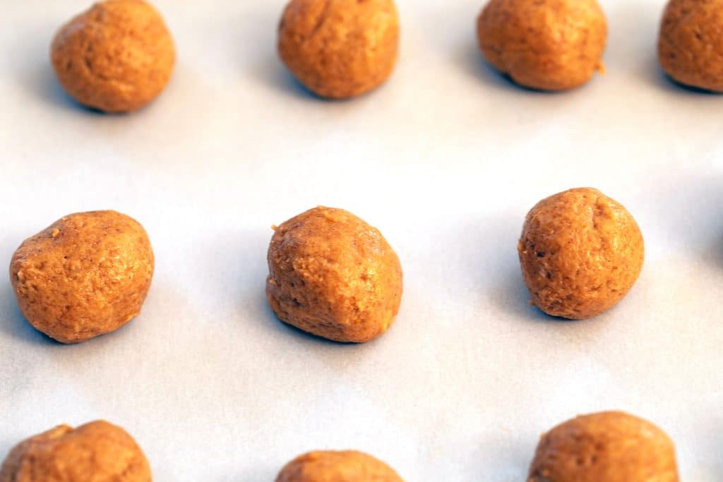 Carrot Cake truffle Oreo balls lined up on a parchment paper-line cookie sheet