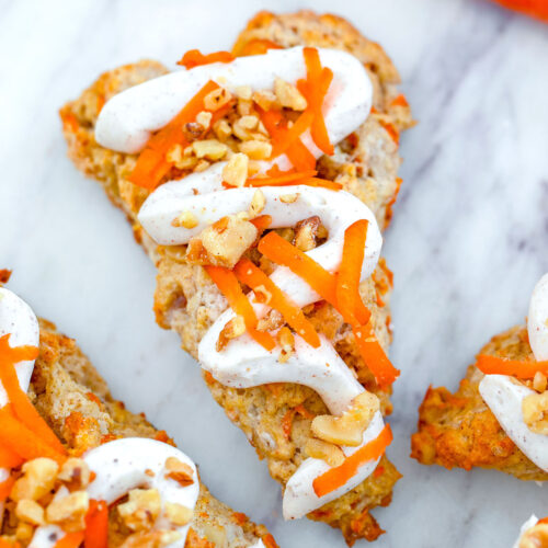 Overhead closeup view of a chai carrot cake scone with cream cheese icing and grated carrot