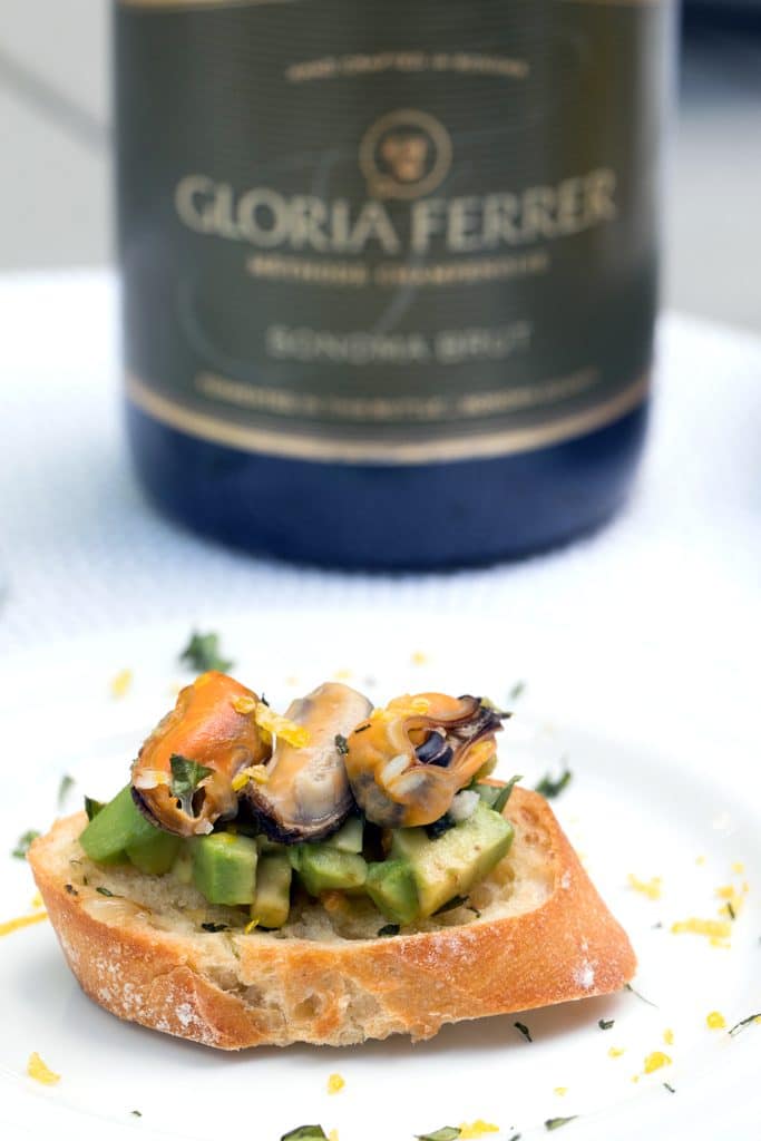 Sparkling Wine Mussel Crostini with Avocado, Grilled Lemon, and Basil -- The perfect party appetizer #GloriousBites | wearenotmartha.com