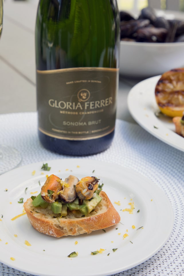 Sparkling Wine Mussel Crostini with Avocado, Grilled Lemon, and Basil -- The perfect party appetizer #GloriousBites | wearenotmartha.com