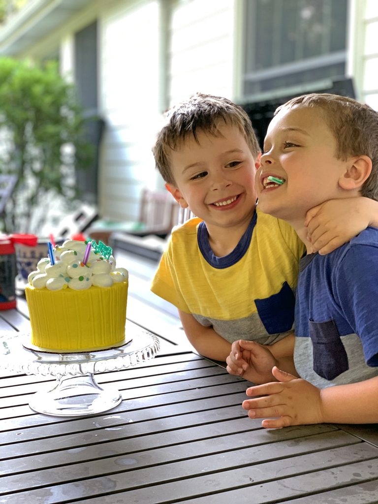 Charlie and Henry sitting outside with their birthday cake