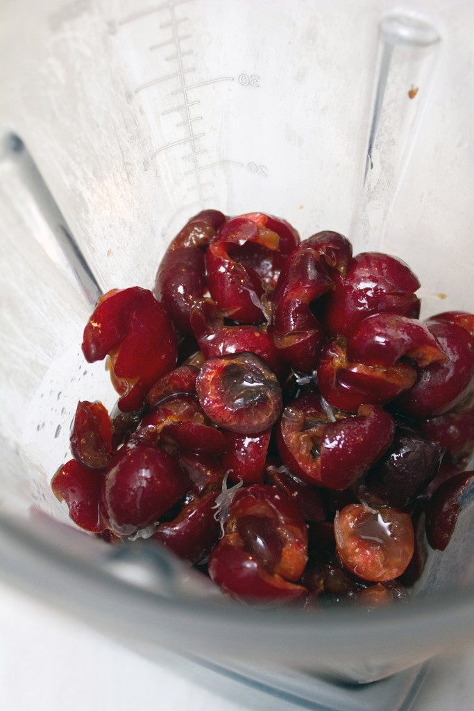 Overhead view of chopped fresh cherries in a blender