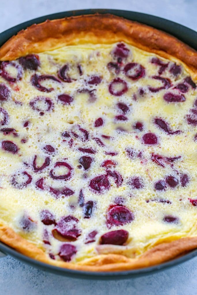 Overhead view of cherry clafoutis in skillet just out of oven with puffed up edges