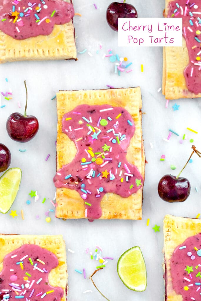 Overhead view of a cherry lime pop tart on a marble surface with more pop tarts, cherries, limes, and sprinkles all around and recipe title at top