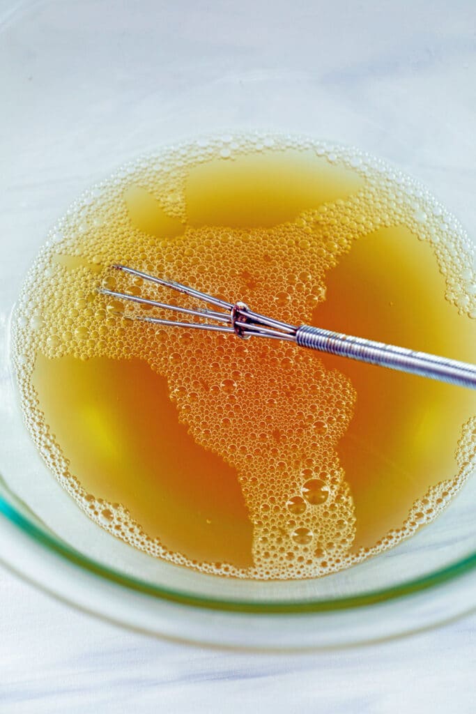 Gelatin and chicken broth mixed together in bowl