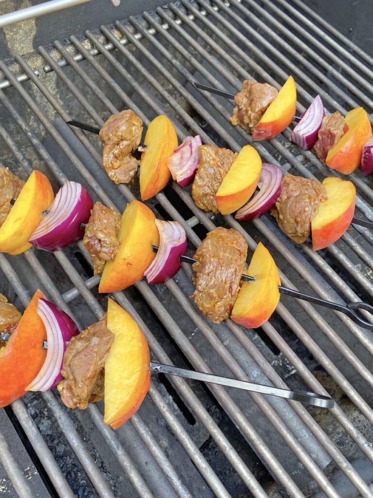 Steak and peach kabobs on grill