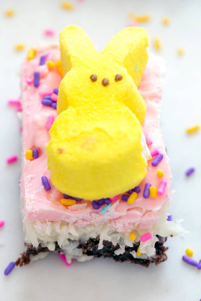 Overhead close-up view of a Peeps brownie bar with pink icing, sprinkles, and a yellow marshmallow Peep