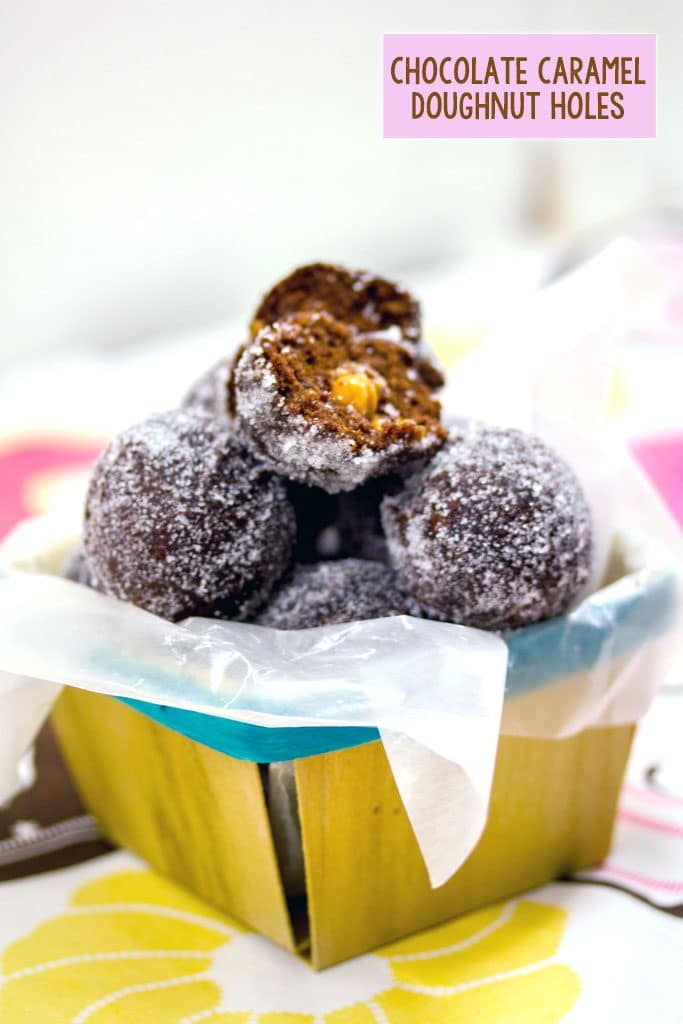 Chocolate doughnut holes stacked in a basket with the top one cut open with caramel oozing out and "Chocolate Caramel Doughnut Holes" text at top