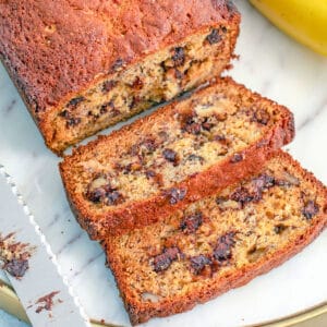 Overhead closeup view of a loaf of chocolate chip banana bread with a couple slices cut