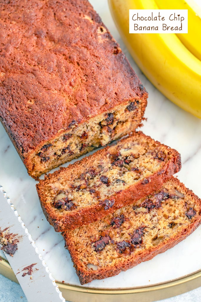 Overhead closeup view of a loaf of chocolate chip banana bread with a couple slices cut a knife and bananas in the background with recipe title at top.