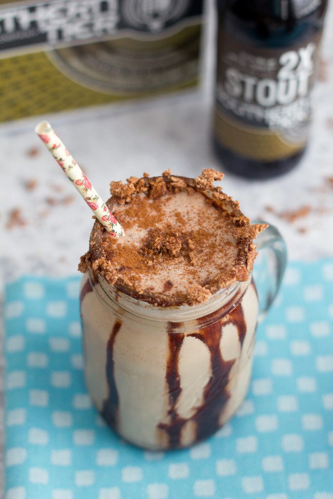 Overhead view of a Chocolate Cinnamon Toast Crunch stout milkshake in a mason jar with chocolate syrup and cereal on rim with straw